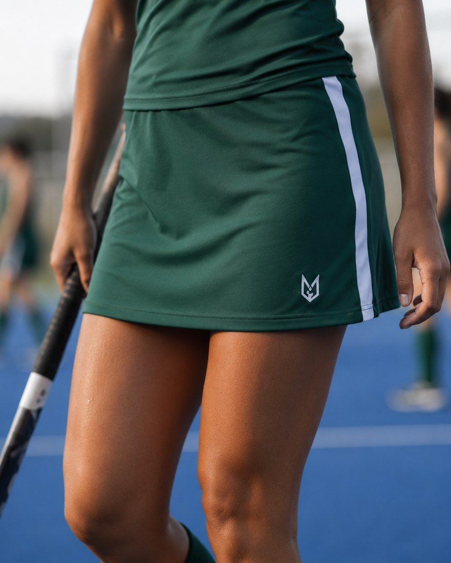 Field hockey player in a green skort with a side stripe