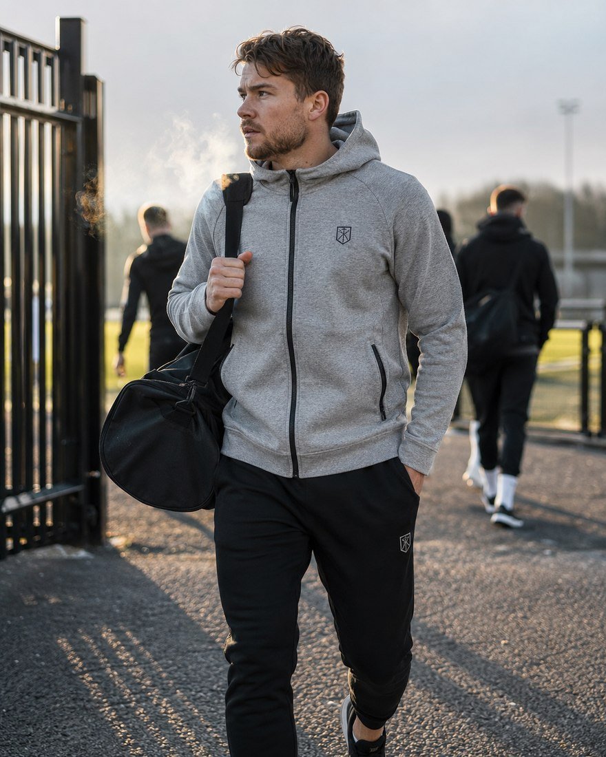 Athlete walking through a stadium gate carrying a kit bag